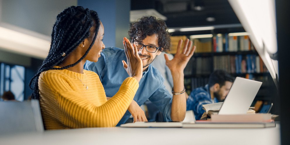 Zwei Forschende in der Bibliothek